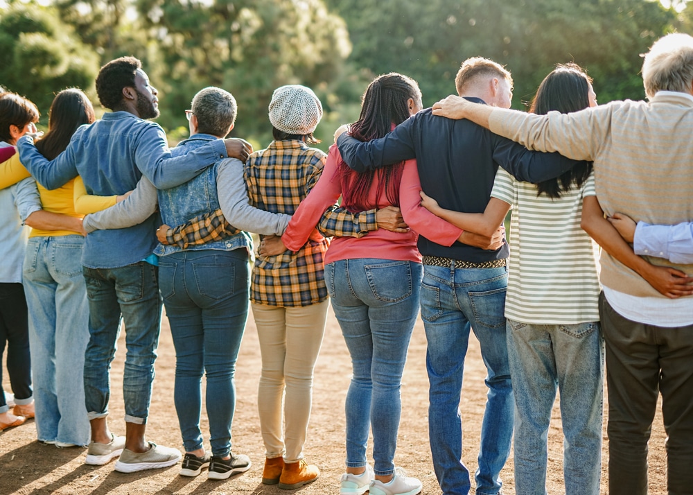 Eine Gruppe Menschen hält sich im Arm